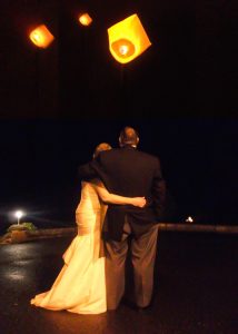 Back view of Bride and Groom watching  Chinese lanterns rise into the sky